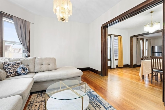 570 William St, Fall River, MA 02721 - living room featuring a chandelier, light wood-style floors, and baseboards
