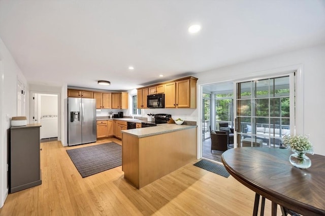 13 Pickerel Way, Sandwich, MA 02644 - kitchen with black appliances, a peninsula, light wood-style flooring, washer / dryer, and recessed lighting