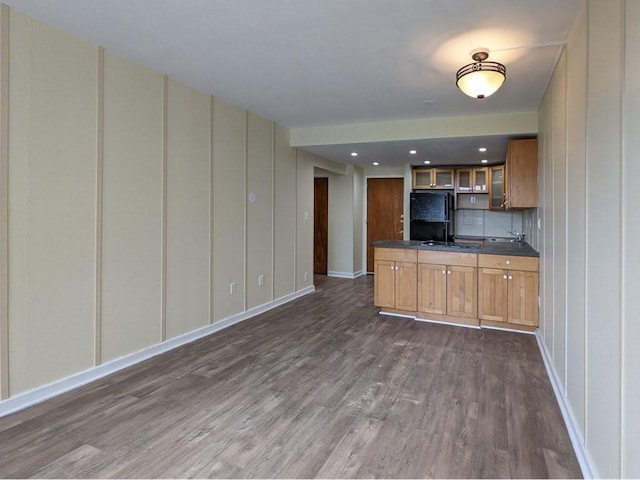 kitchen featuring black fridge and dark hardwood / wood-style flooring