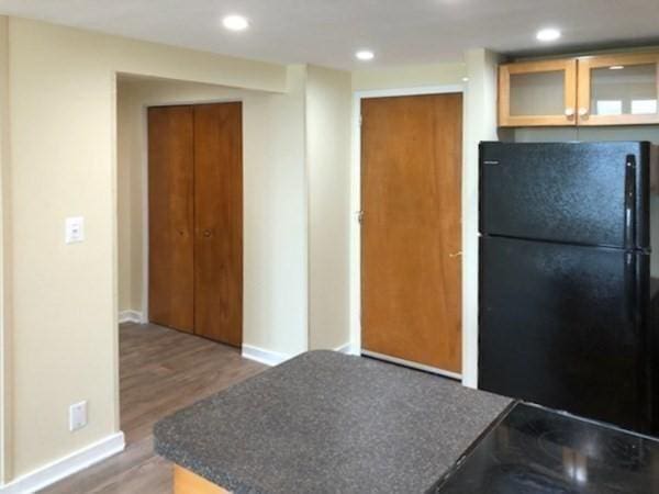 kitchen featuring black fridge and dark wood-type flooring