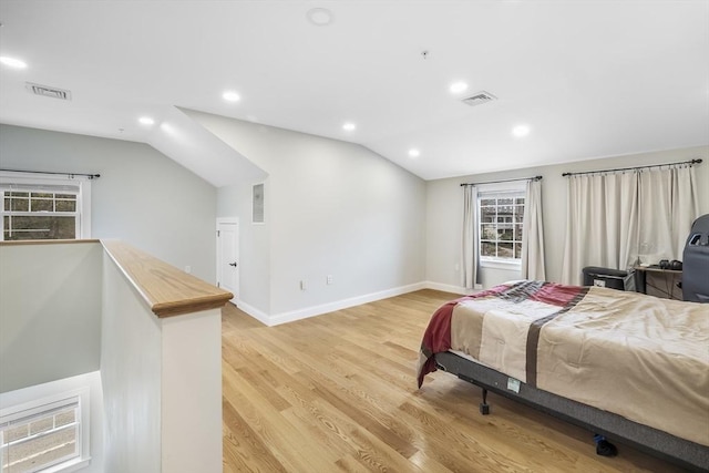 bedroom featuring baseboards, vaulted ceiling, light wood-type flooring, and visible vents