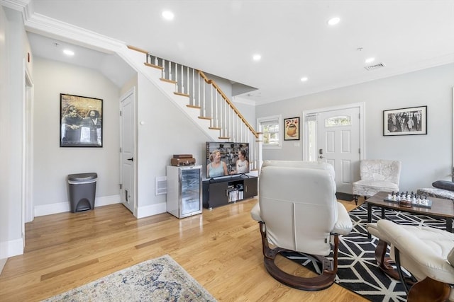 living room with a dry bar, light wood-style flooring, recessed lighting, visible vents, and stairway