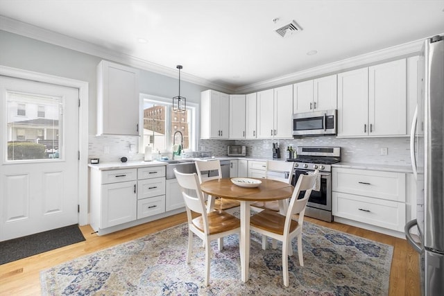 kitchen with visible vents, light countertops, white cabinetry, tasteful backsplash, and stainless steel appliances
