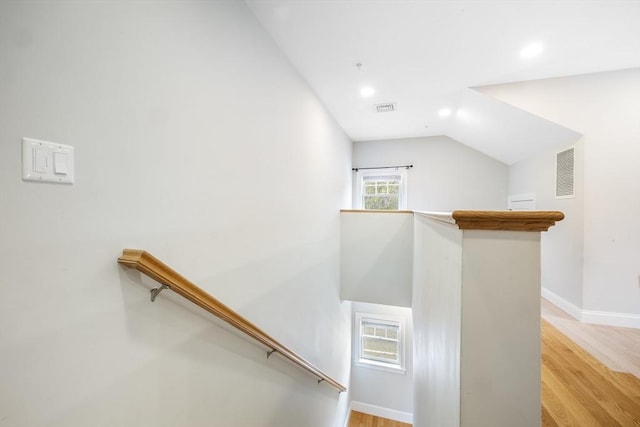 stairway featuring recessed lighting, vaulted ceiling, wood finished floors, and visible vents