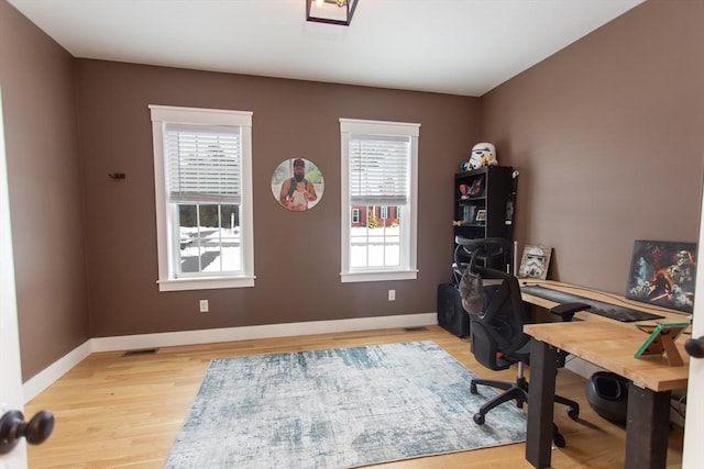 office area with visible vents, light wood-type flooring, and baseboards