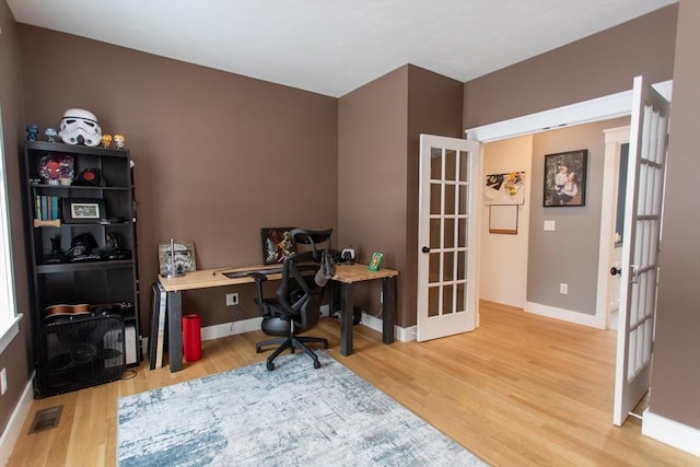 office featuring visible vents, french doors, light wood-type flooring, and baseboards