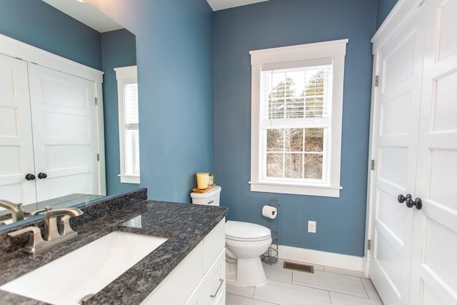 bathroom featuring vanity, baseboards, visible vents, tile patterned flooring, and toilet