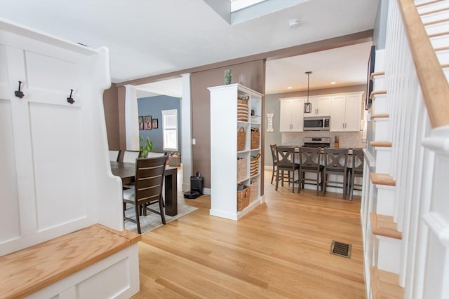 interior space with baseboards, visible vents, recessed lighting, stairs, and light wood-type flooring