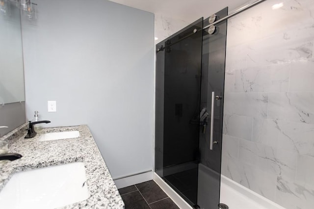 full bathroom featuring tile patterned floors, a stall shower, double vanity, and a sink