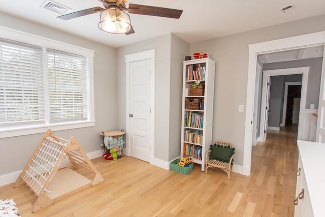 recreation room featuring light wood-style flooring, baseboards, visible vents, and ceiling fan