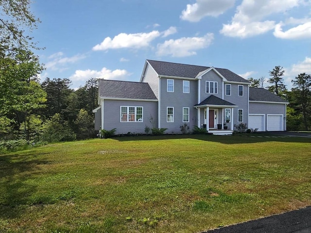 colonial home featuring aphalt driveway, a front yard, and an attached garage