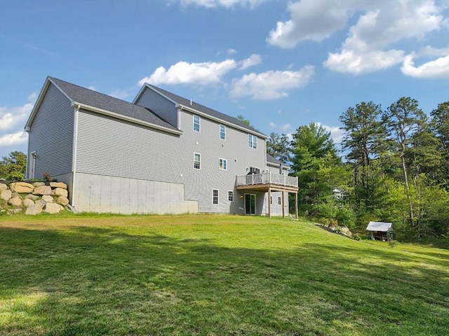 rear view of property featuring a deck and a yard