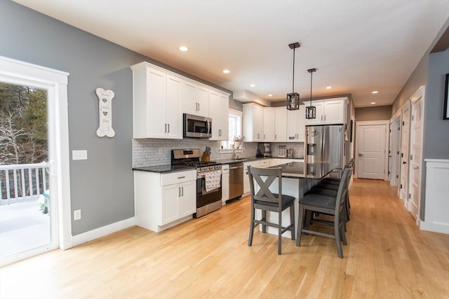 kitchen featuring tasteful backsplash, a kitchen breakfast bar, stainless steel appliances, and a sink