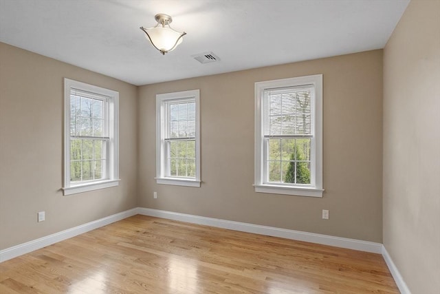empty room featuring baseboards and light wood-type flooring