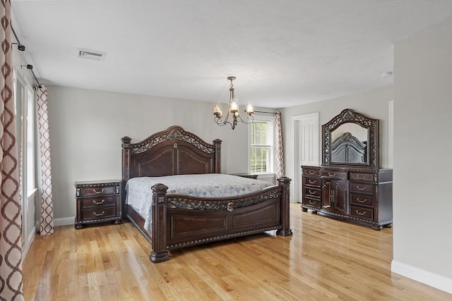 bedroom featuring light wood-style floors, baseboards, and a chandelier
