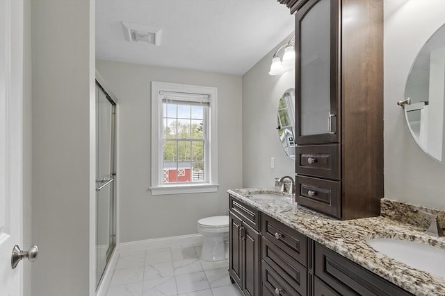 full bathroom featuring marble finish floors, toilet, baseboards, double vanity, and a shower stall
