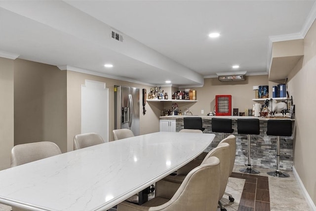 dining space with bar with sink, recessed lighting, and ornamental molding
