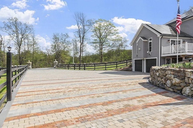 view of patio / terrace featuring decorative driveway and a garage