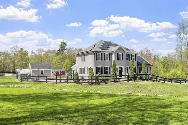 rear view of property with solar panels, an outbuilding, and a storage unit