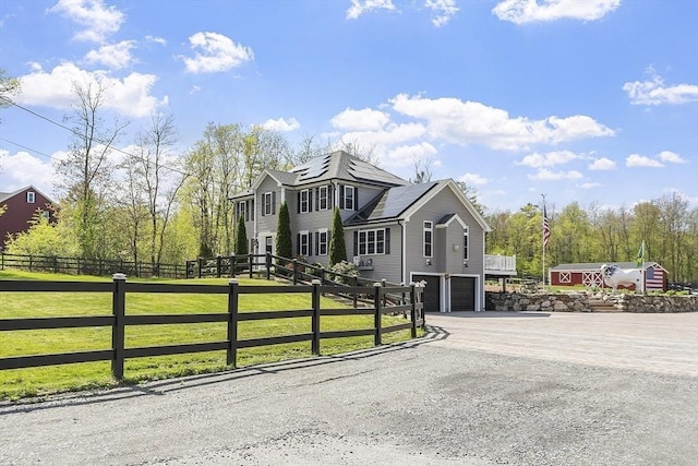 view of front of property featuring an attached garage, driveway, and solar panels