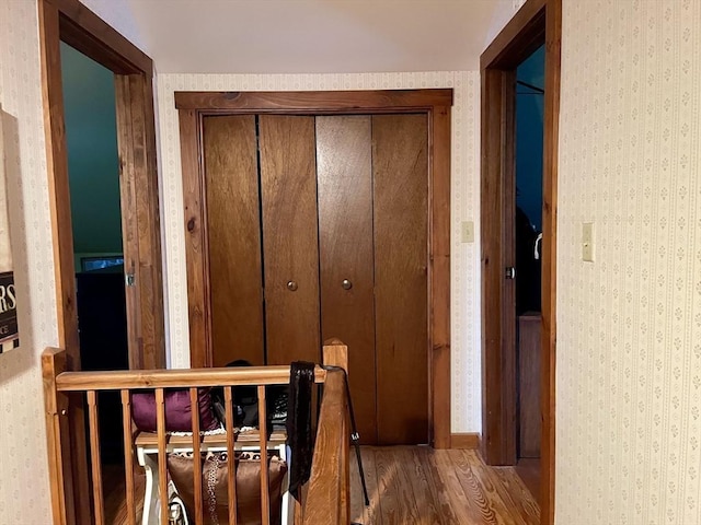 hall featuring wallpapered walls and wood finished floors