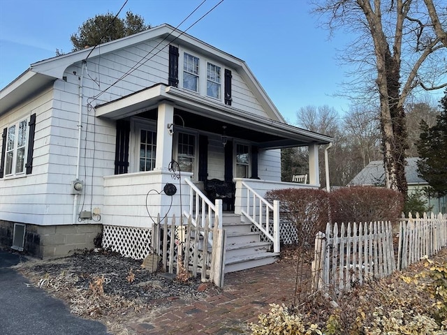 bungalow featuring a porch and fence