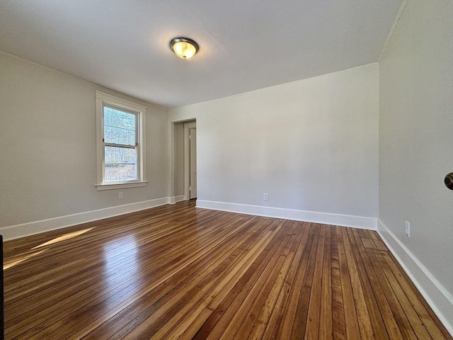 empty room with dark wood-style floors and baseboards