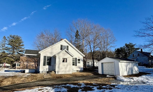 exterior space featuring a detached garage and an outbuilding