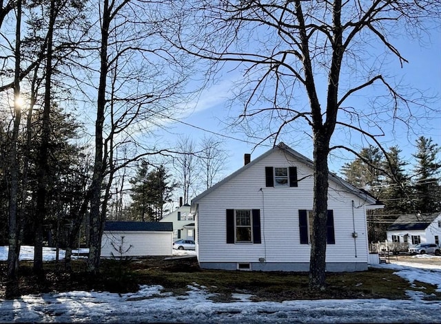 snow covered property with a chimney