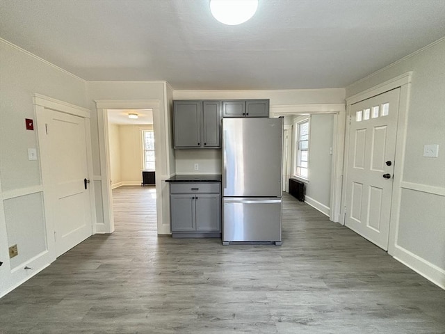 kitchen with dark wood-style flooring, crown molding, gray cabinets, and freestanding refrigerator