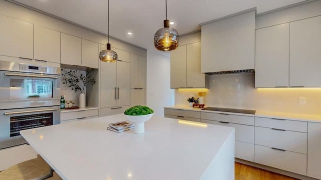 140 Columbia St Unit 2, Brookline, MA 02446 - kitchen featuring black electric stovetop, stainless steel double oven, light countertops, recessed lighting, and backsplash