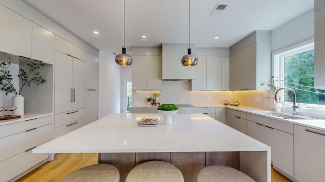 140 Columbia St Unit 2, Brookline, MA 02446 - kitchen with a sink, modern cabinets, a breakfast bar, and recessed lighting