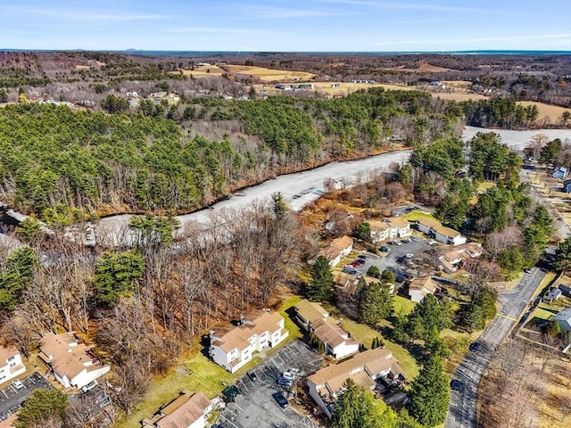 drone / aerial view featuring a wooded view and a water view