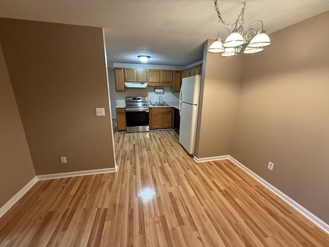 58 Randolph Dr Unit 58, Tewksbury, MA 01876 - kitchen featuring stainless steel electric range oven, freestanding refrigerator, light wood-style floors, light countertops, and under cabinet range hood