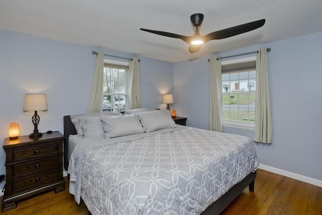 bedroom featuring a ceiling fan, baseboards, and wood finished floors