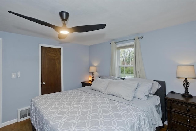 bedroom with baseboards, a ceiling fan, dark wood-type flooring, and visible vents