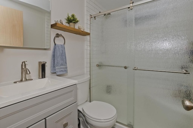 bathroom featuring vanity, a stall shower, and toilet