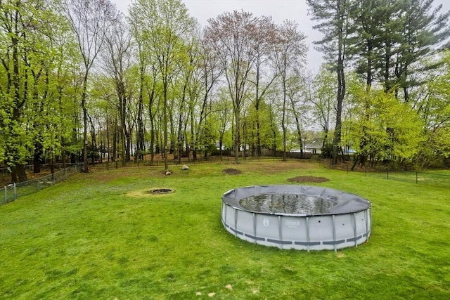 view of yard with a fenced backyard and a covered pool