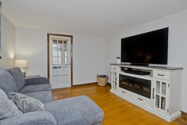 living room with baseboards and light wood finished floors