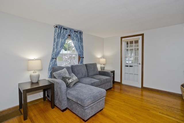 living area featuring baseboards and light wood-type flooring