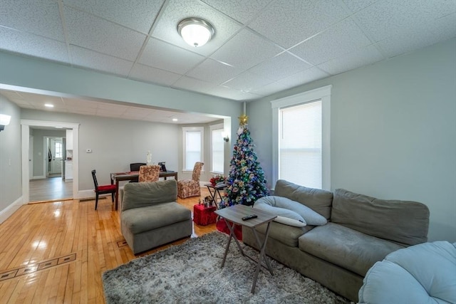 living room featuring a paneled ceiling and hardwood / wood-style floors