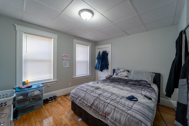 bedroom featuring a paneled ceiling and wood-type flooring