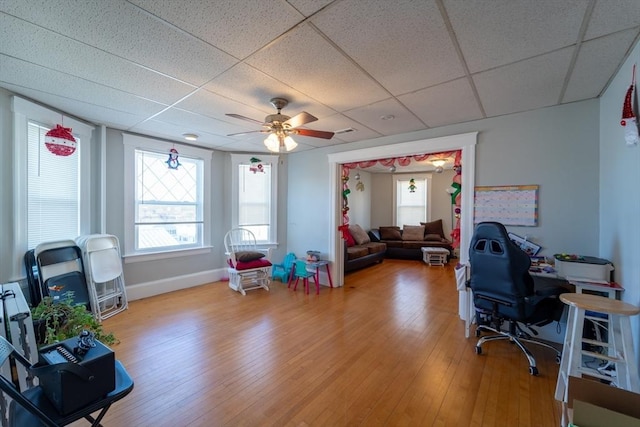 home office with ceiling fan, hardwood / wood-style floors, and a paneled ceiling