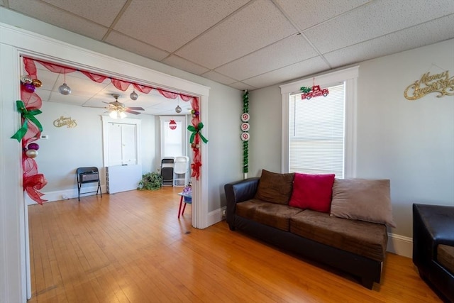 living room with ceiling fan, hardwood / wood-style floors, and a drop ceiling