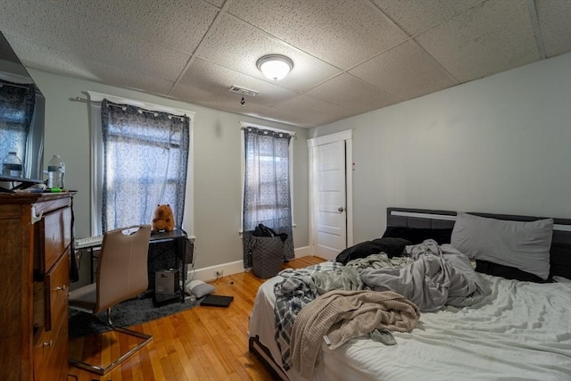 bedroom featuring a paneled ceiling and wood-type flooring