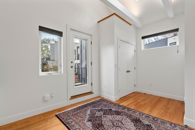 entryway featuring beamed ceiling and wood-type flooring