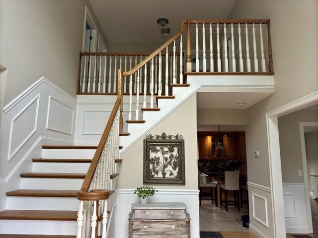 6 Cedar Creek Dr, Attleboro, MA 02703 - stairway featuring wainscoting, tile patterned flooring, and a decorative wall
