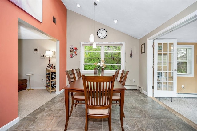 dining room featuring lofted ceiling, baseboard heating, baseboards, and stone finish floors