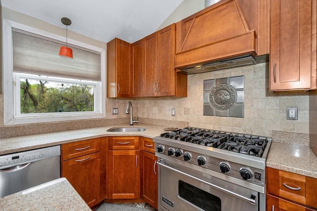 kitchen with a sink, appliances with stainless steel finishes, backsplash, brown cabinetry, and lofted ceiling