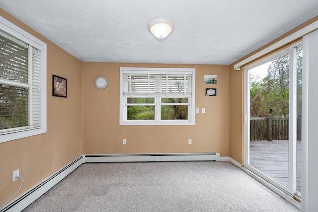carpeted spare room featuring baseboard heating and baseboards